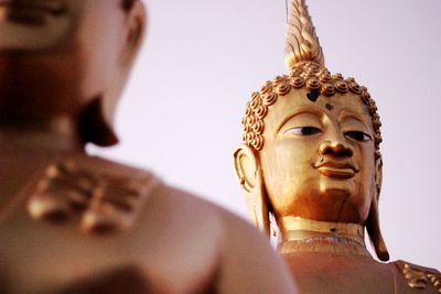 Low angle view of buddha statue against sky