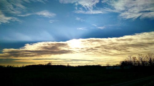 Scenic view of field against cloudy sky