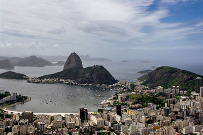 High angle view of cityscape by sugarloaf mountain against cloudy sky