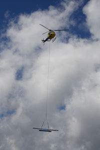 Low angle view of helicopter flying against sky