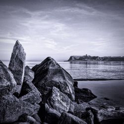 Rocks and beach against sky
