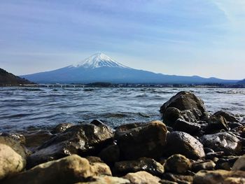 Rocks by sea against sky