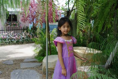 Portrait of cute girl standing against plants