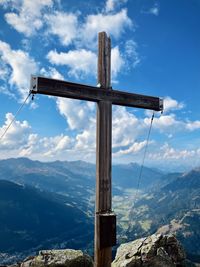 Cross on mountain against sky