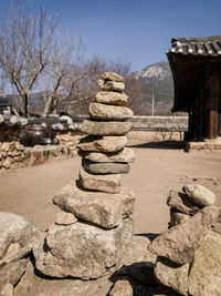 Stack of stones on rock against sky