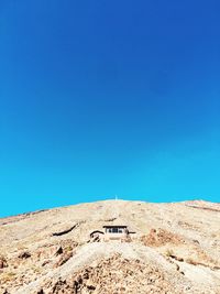 Low angle view of land against clear blue sky