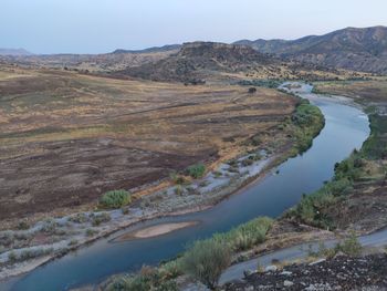 Scenic view of river amidst mountains against sky