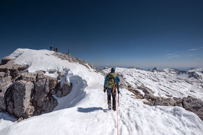 Full length of man standing on mountain during winter against sky