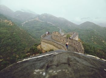 Tourists at great wall of china against sky