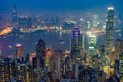 Illuminated cityscape against sky at night