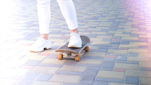 Low section of woman standing on footpath