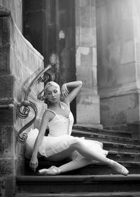 Portrait of woman sitting against built structure