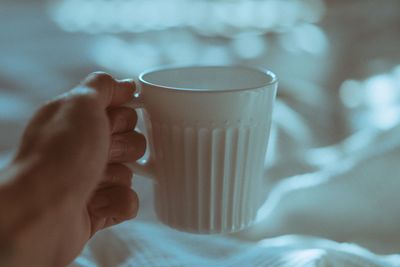 Close-up of hand holding coffee cup