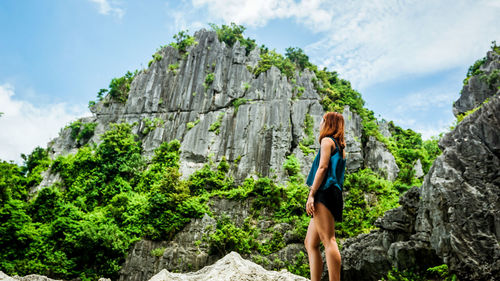 Low angle view of woman standing by mountains