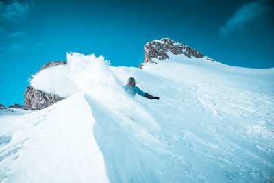 Person skiing on snowcapped mountain against sky