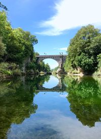 Arch bridge over river against sky