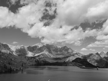 Scenic view of lake by snowcapped mountains against sky