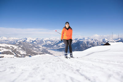 Full length of woman skiing on snow covered mountain