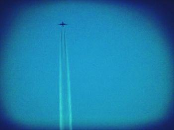 Low angle view of trees against clear blue sky