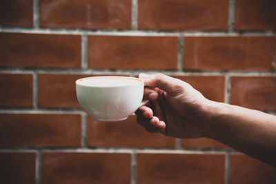 Close-up of hand holding coffee cup