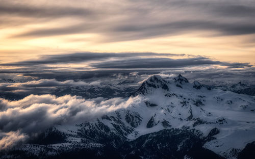 Scenic view of snowcapped mountains against sky during sunset