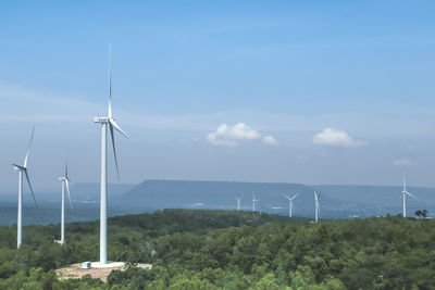 Wind turbines on land against sky