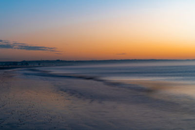 Scenic view of beach against sky during sunset