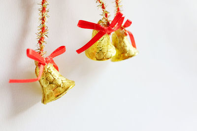 Close-up of christmas bells hanging against white background