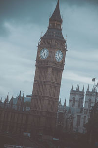 Low angle view of clock tower against cloudy sky