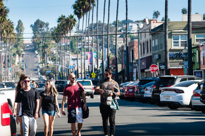 People walking on road along buildings