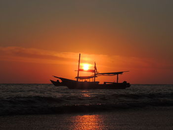 Silhouette ship in sea against sky during sunset