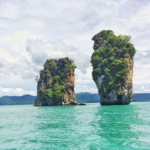 Standing rocks in calm sea against the sky