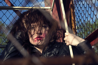 Portrait of young woman with messy hair and lipstick in cage