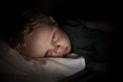 Portrait of cute boy lying on bed