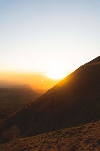 Scenic view of landscape against clear sky during sunset