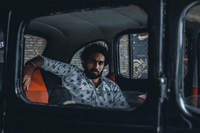 Portrait of young man sitting in car