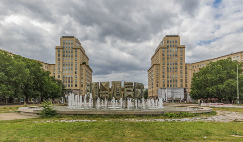 Buildings in city against cloudy sky