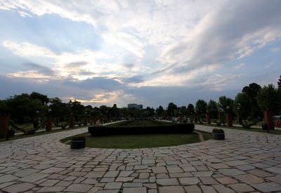 View of footpath against cloudy sky