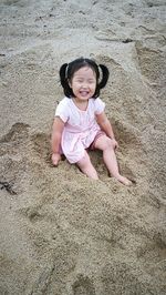 Portrait of smiling girl on sand at beach