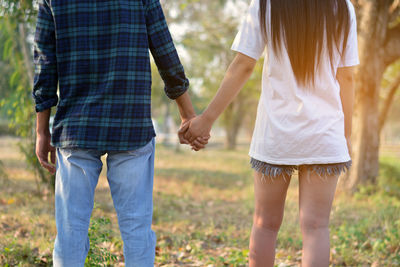 Rear view of couple holding hands