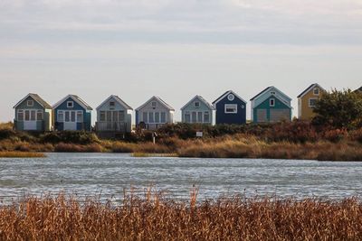 Houses by lake against sky