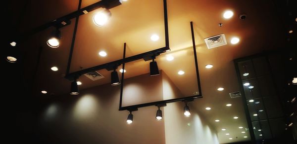 Low angle view of illuminated pendant lights hanging from ceiling