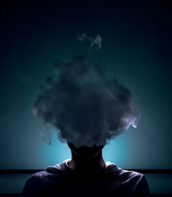 Portrait of man smoking against sky