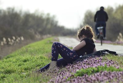 Side view of woman sitting on field