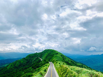 Panoramic view of road leading towards mountains against sky