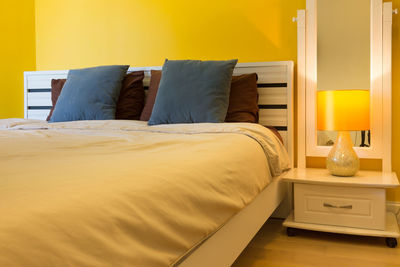 View of yellow bed in bedroom