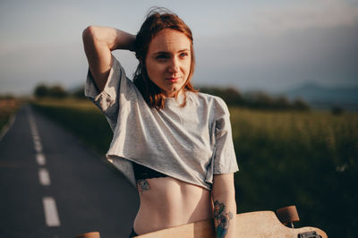 Portrait of young woman standing against sky