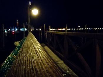 Illuminated footbridge over street in city at night