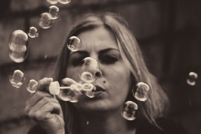 Close-up of woman blowing bubbles