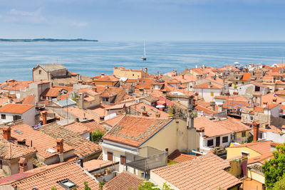 High angle view of townscape by sea against sky